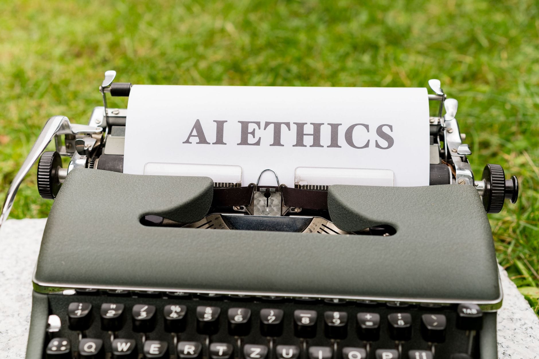 Stara maszyna do pisania na dworze z kartką z napisem AI ethics