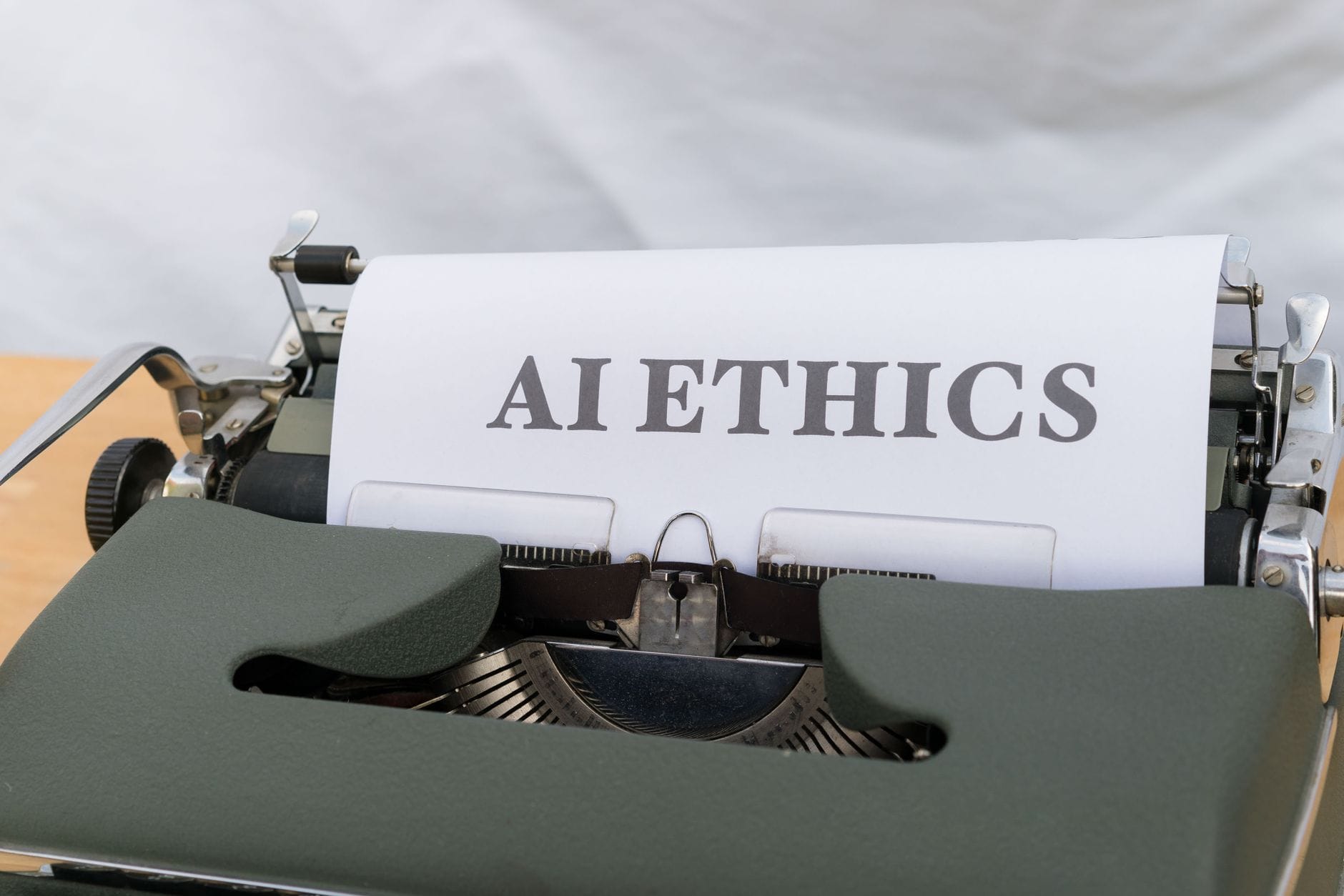 Zbliżenie maszyny do pisania z napisem AI ETHICS na kartce