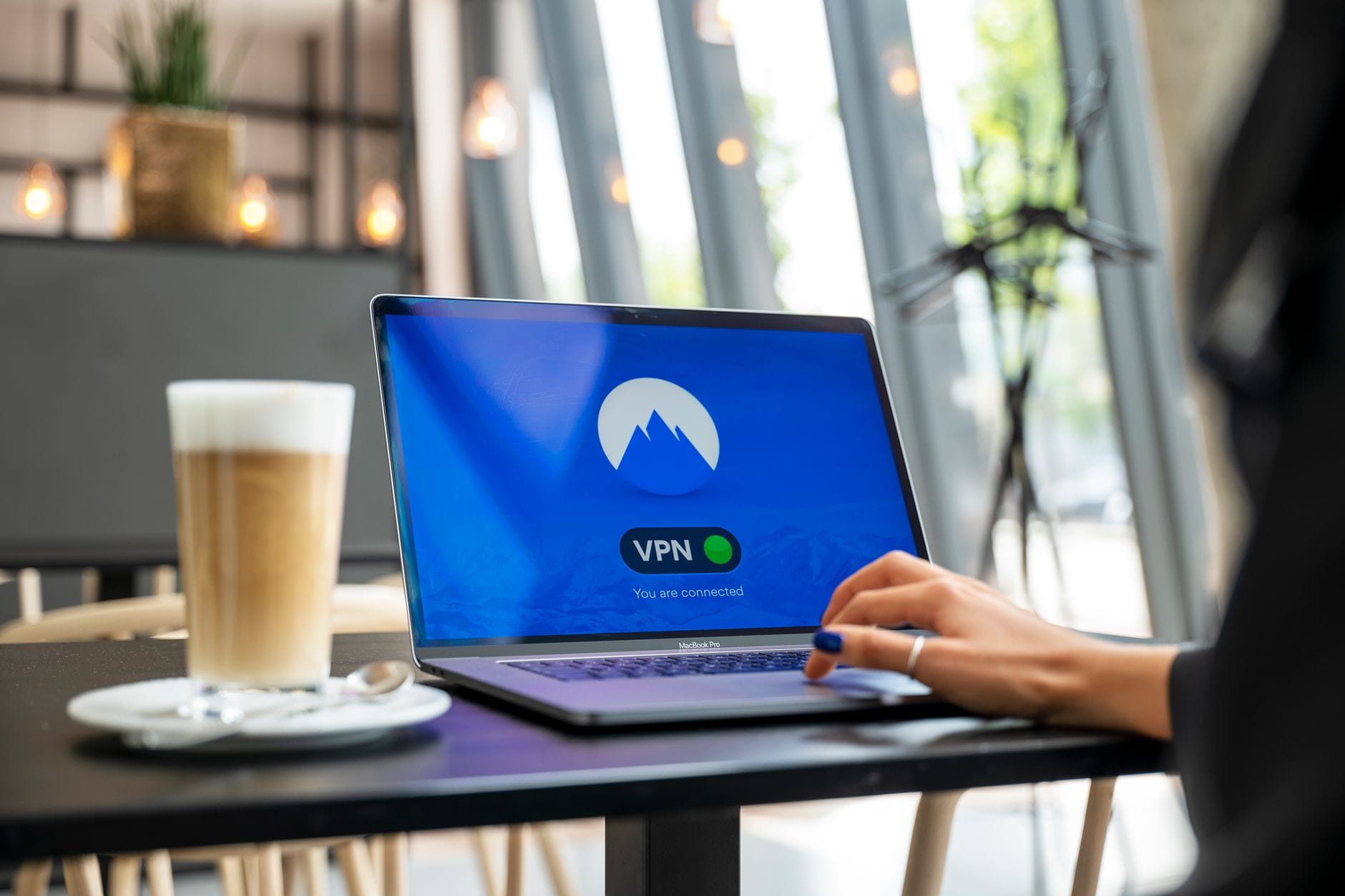 Jak bezpiecznie korzystać z publicznego Wi Fi praktyczny poradnik dla każdego Osoba w kawiarni korzysta z laptopa z włączonym VPN dla bezpieczeństwa internetu