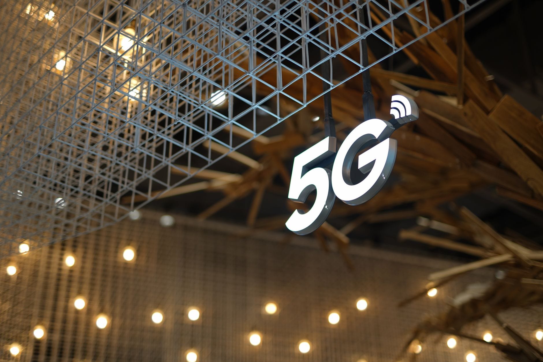 Podświetlony napis 5G na tle nowoczesnego geometrycznego sufitu