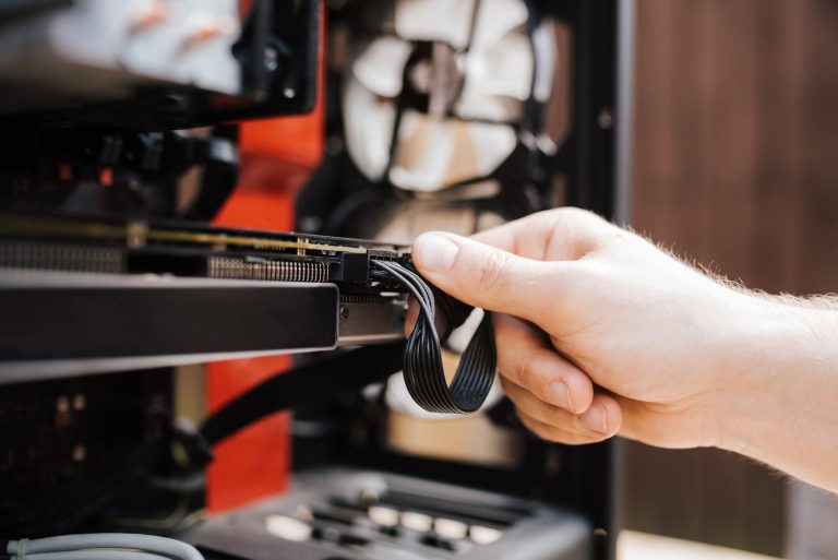 Technik podłącza kable w obudowie komputera